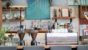 A coffee shop counter with a menu board, coffee machines, and various coffee-related items. - Phuket View Coffee and Resort (Chalong)