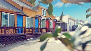 A row of colorful beach houses with wooden decks and railings.
