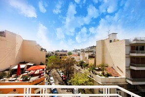 A view of a residential area with buildings, trees, and parked cars. - Your Home under the Acropolis Roofdeck (Athens)