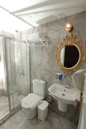 A bathroom with a glass-enclosed shower, a toilet, a sink, and a vanity. - Constantinopolis Hotel (Istanbul)