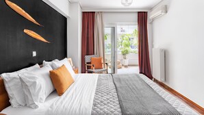 Camera d'albergo moderna con un letto grande, una parete d'accento nera e vista sull'esterno tramite una porta scorrevole in vetro.