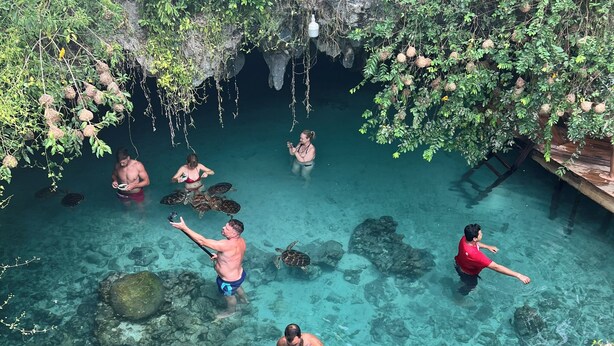 A group of people in a natural pool surrounded by greenery and rocks. - Gadea Boutique Hotel (Jambiani)