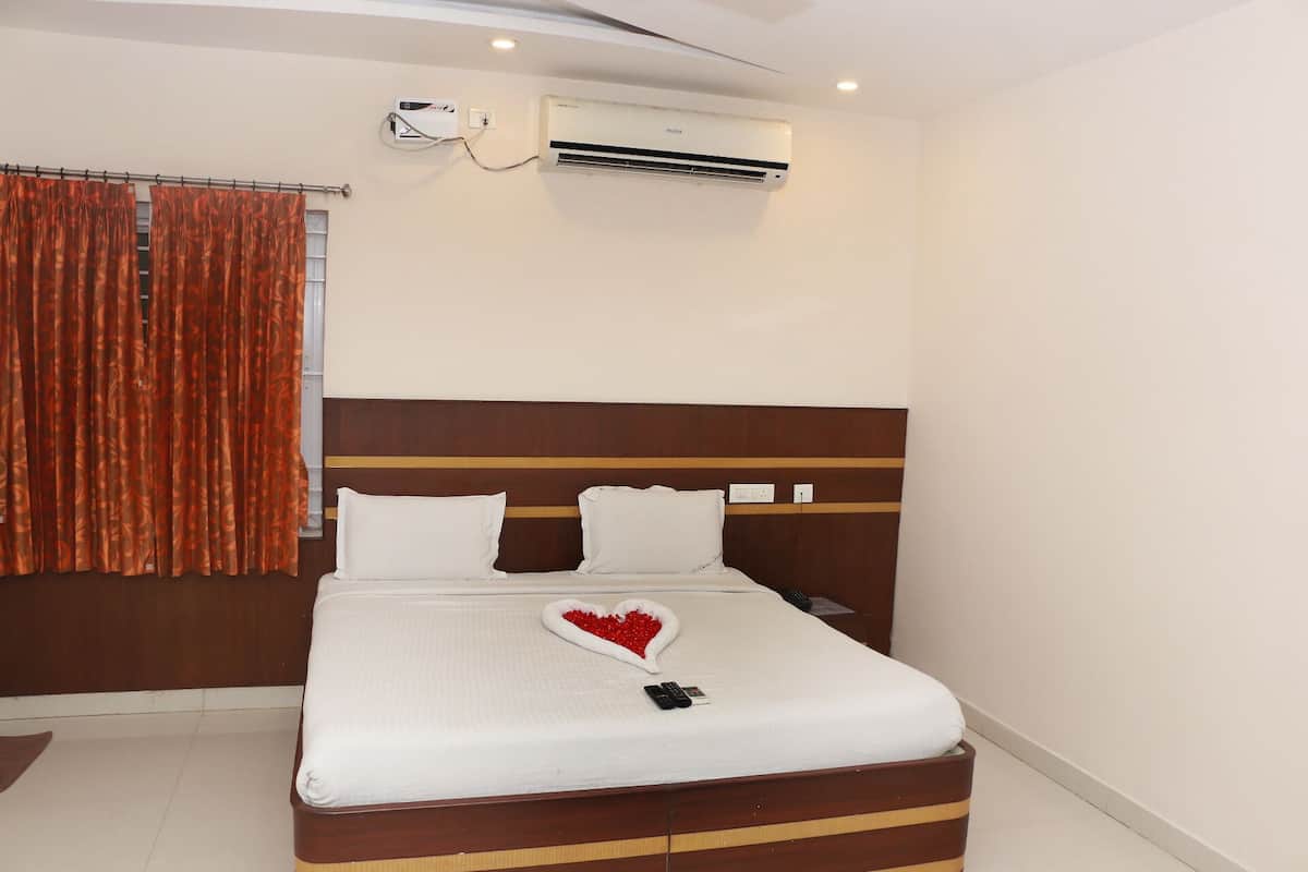 Una habitación de hotel con cama, aire acondicionado y ventana con cortinas.