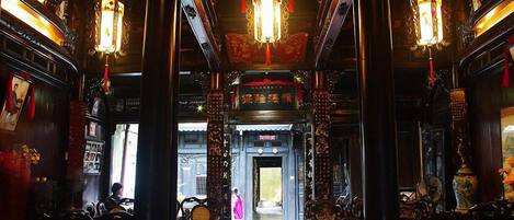 An ornate interior with traditional Chinese architectural elements, including intricate woodwork and hanging lanterns.