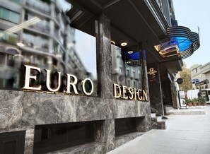 The exterior of the EURO DESIGN hotel with a modern facade, large illuminated lettering, and a distinctive blue glass feature. - Euro Design Hotel (Istanbul)