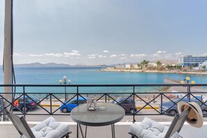 A balcony with a view of the sea, a table with a glass, and two chairs. - Chic Modern Seaside Oasis -Sunny Piraeus (Piraeus)