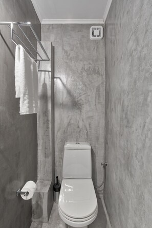 A modern bathroom with a shower, toilet, and towel rack. - Chic Modern Seaside Oasis -Sunny Piraeus (Piraeus)