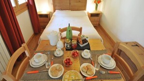 Una preparación para el desayuno con una mesa de madera, sillas y una cama con cabecero de madera.