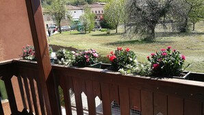 Un balcón con barandillas de madera y macetas con flores.