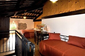 Une pièce confortable avec un lit, un bureau et une chaise. Il y a une fenêtre avec des rideaux et une vue sur la verdure à l’extérieur.