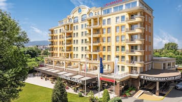 Un hotel a più piani con balconi, un giardino e un cartello con la scritta "Landmark Hotel".