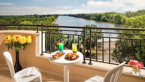 A balcony with a table set for two, featuring a vase of flowers, a plate of pastries, and two drinks. - Landmark Creek Hotel & Wellness (Plovdiv)