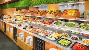 A buffet with various food items and a wine cooler. - Landmark Creek Hotel & Wellness (Plovdiv)