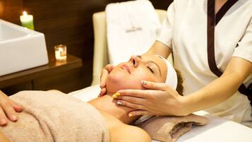 Une personne qui reçoit un soin du visage dans un spa.