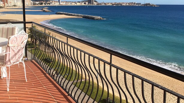 A balcony with a view of the beach and ocean, featuring a table and chairs. - Exceptional location, 1st line of the sea, 86m2 apartment with terrace (Sant Antoni de Calonge)
