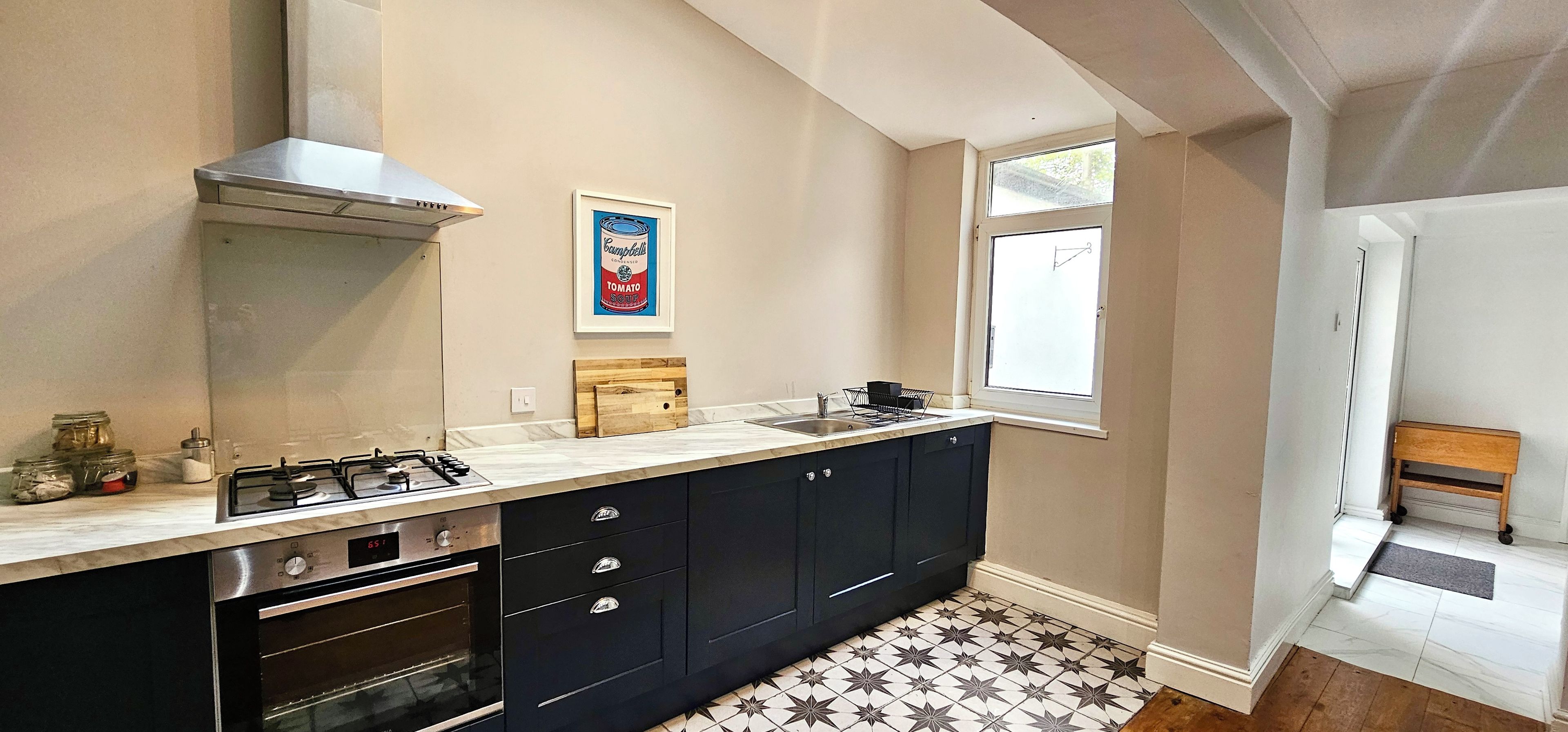 A kitchen with a gas stove, oven, and a window with a view.