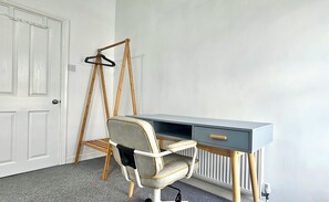 A room with a desk, a chair, a radiator, and a door. - Railway Street by Switchback Stays (Cardiff)