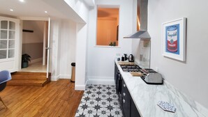 A modern kitchen with a skylight, a gas stove, and a framed picture of Campbell's Tomato Soup. - Railway Street by Switchback Stays (Cardiff)