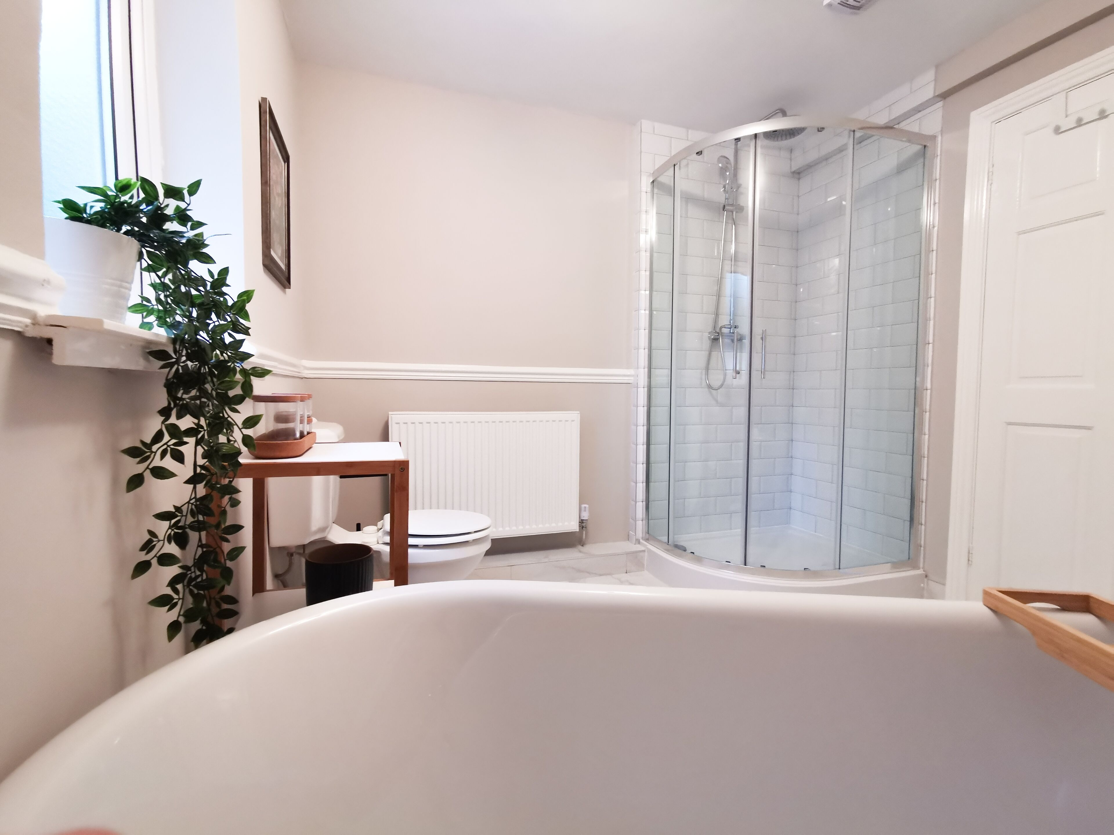 Une salle de bain moderne avec une douche à parois de verre, une baignoire blanche et des toilettes.