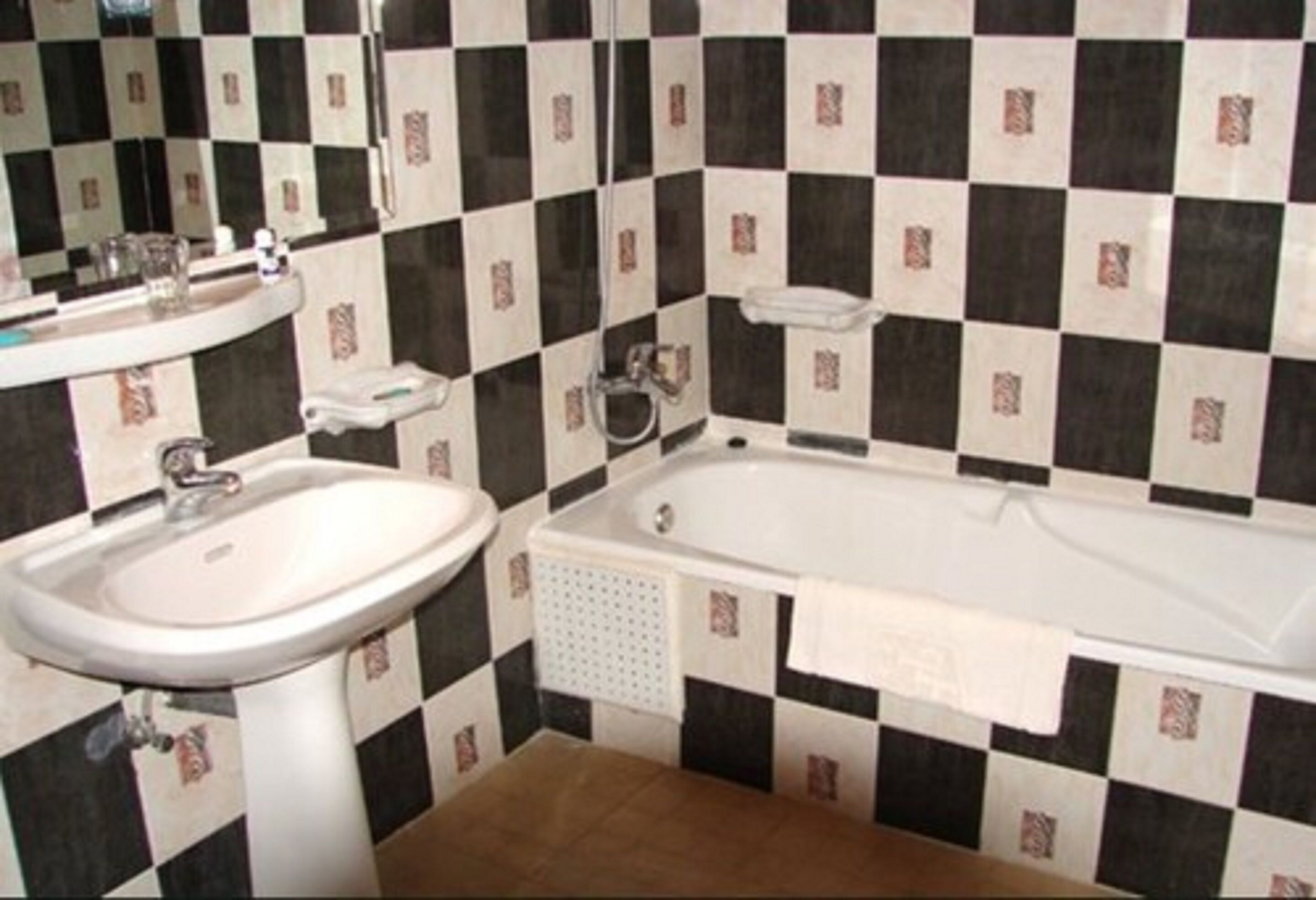 A bathroom with a sink, a bathtub, and a mirror.