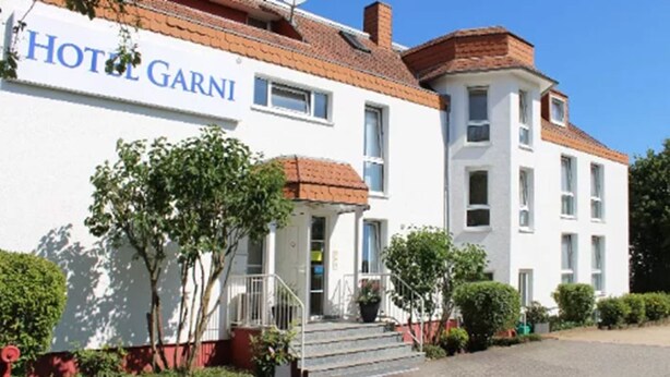 Un edificio blanco con un cartel que dice "HOTEL GARNI".