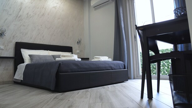 A modern bedroom with a bed, a desk, and a window. - B&B Agrigento da Tony Palermo (Agrigento)