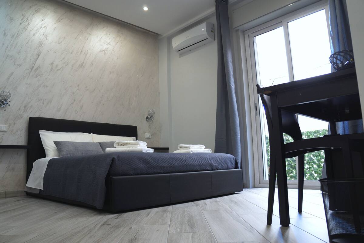 Quarto moderno com uma cama, uma escrivaninha e uma janela.