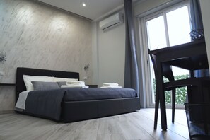 A modern bedroom with a bed, a desk, and a window. - B&B Agrigento da Tony Palermo (Agrigento)