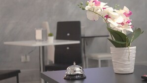 A desk with a white orchid in a textured pot, a black bell, and a laptop in the background. - B&B Agrigento da Tony Palermo (Agrigento)