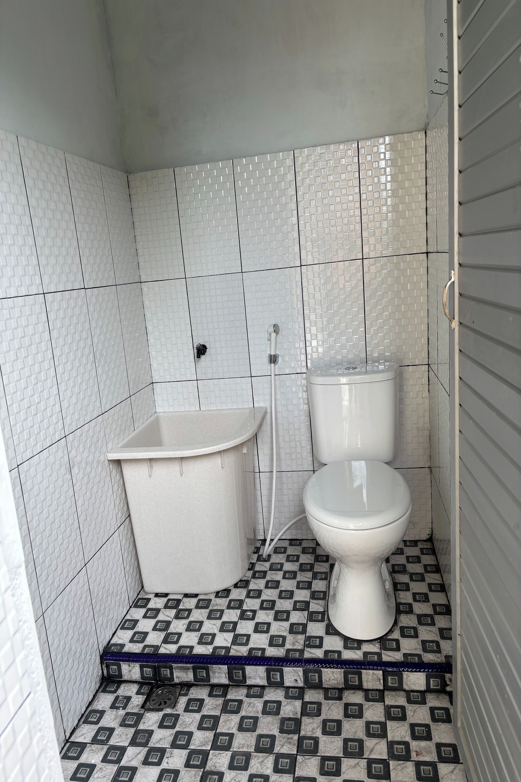 Une petite salle de bain avec des toilettes, un lavabo et une douche.