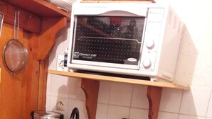 Eine Küche mit Mikrowelle, Kaffeemaschine, Spüle und Geschirrgestell.