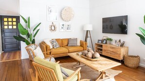 A modern living room with a sofa, coffee table, and a TV.
