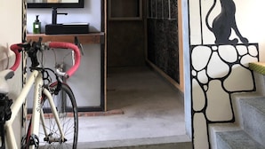 A room with a bicycle, a sink, and a cat silhouette on the wall. - Shadow House (Tainan)