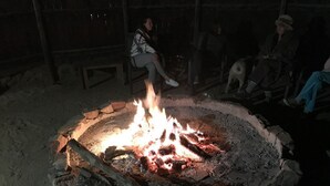 Ein Lagerfeuer, um das Menschen sitzen.