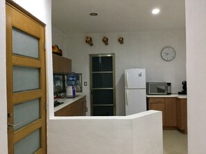 A compact kitchen with a refrigerator, microwave, and water dispenser.