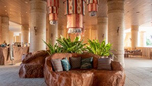 A lobby with a large rock planter, multiple hanging lamps, and a reception desk.