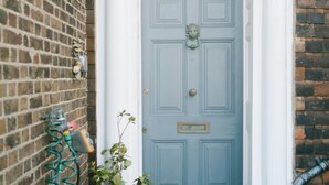 A blue door with a white archway, a potted plant, and a metal gutter on a brick wall. - A stunning Grade II listed apartment in the heart of the conservation area. (Deal)