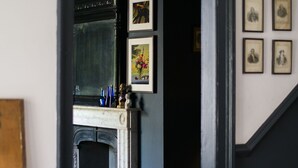 A room with a fireplace, a staircase, and a bookshelf. - A stunning Grade II listed apartment in the heart of the conservation area. (Deal)