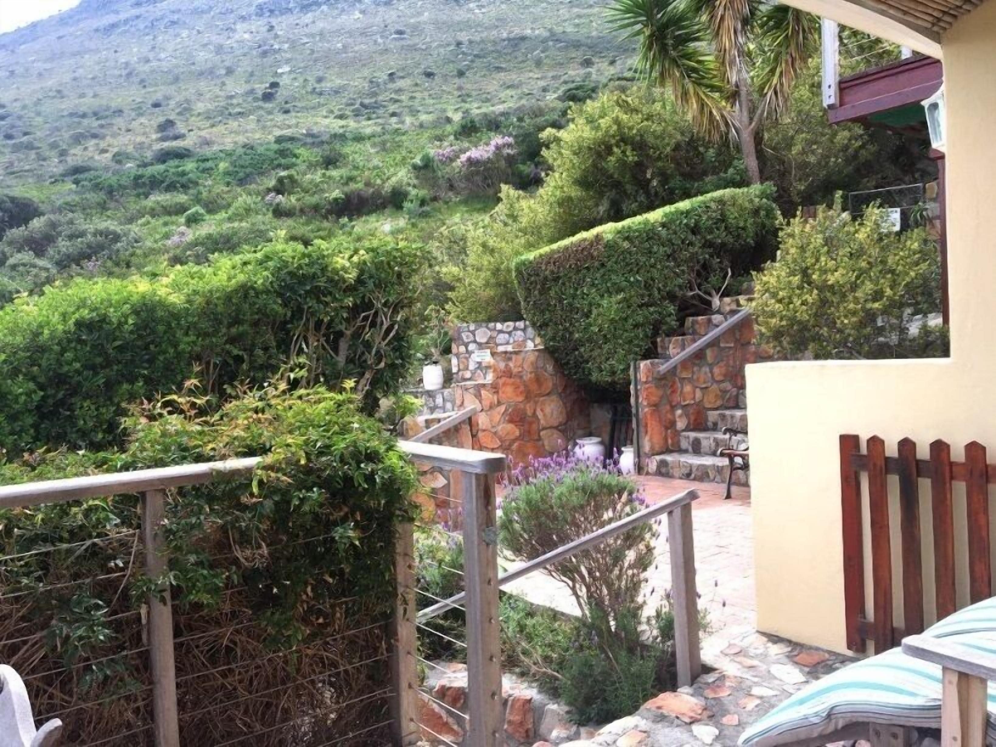 A stone staircase leading to a terrace with a view of a lush hillside.