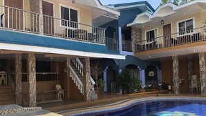 A multi-story building with a swimming pool, balconies, and a staircase leading to the upper floors. - Seaview Beach Resort (Anda)