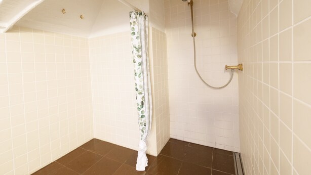 A small, tiled bathroom with a shower and a curtain. - Direct Inner City Deluxe 1 (Copenhagen)