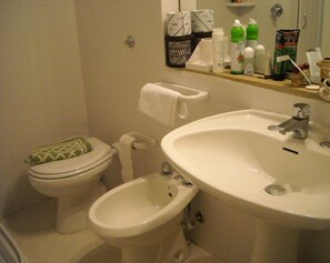 A bathroom with a toilet, bidet, and sink. There are toiletries on the counter. - Club Hotel Marina 2 (Campo nell'Elba)