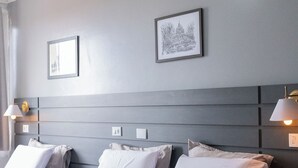 A hotel room with a large bed, two bedside tables, a headboard with built-in lighting, and two framed pictures on the wall. - Euro Hotel (Ubirata)