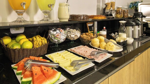 A buffet with various food items and beverages. - Euro Hotel (Ubirata)