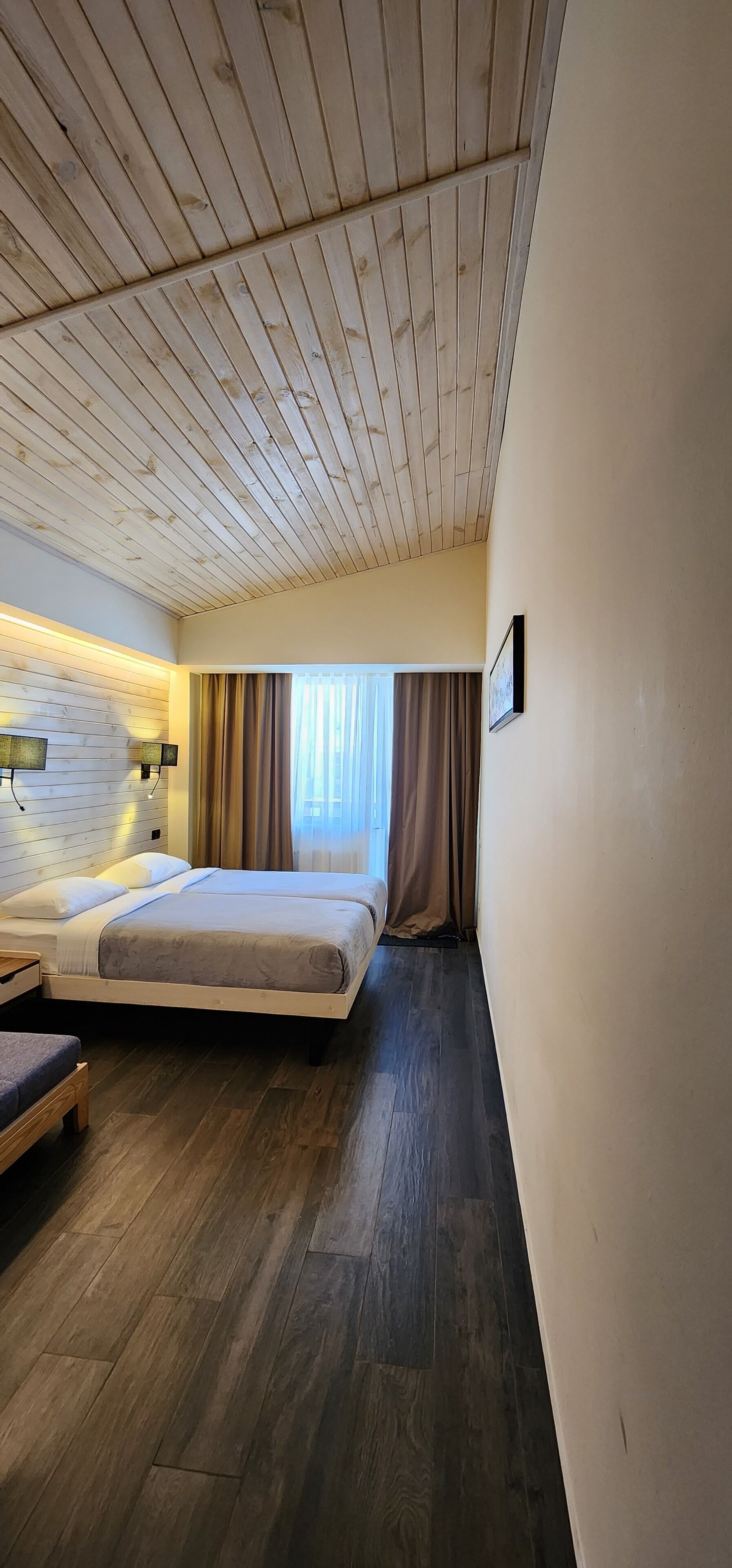Ein Schlafzimmer mit Holzboden, einem Bett, einem Nachttisch und einem Beistelltisch.