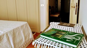 A room with a bed, a table with books, and a door. - Piazza Del Grano Treviso (Treviso)