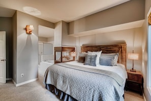 Une chambre Ă coucher avec un grand lit, des lampes de chevet, une table de chevet et un miroir.