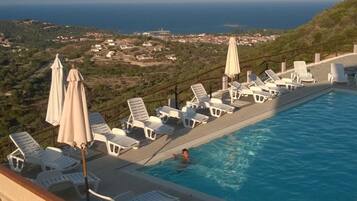 Una piscina al aire libre de temporada, sombrillas
