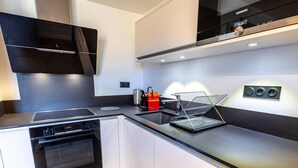 Una cocina moderna con horno integrado, estufa y microondas.