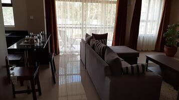 Deluxe Apartment, 1 Bedroom, Kitchenette, City View | Living room | 32-inch TV with digital channels